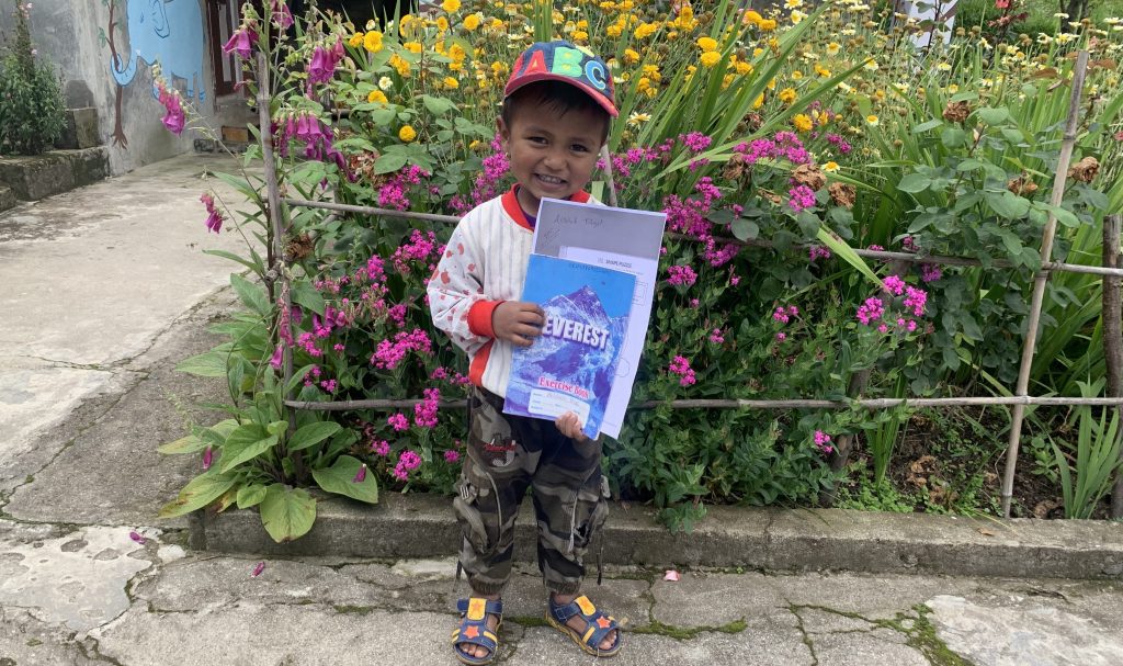 Junge erhält Lernpaket Nepal